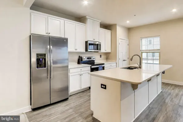 a kitchen with stainless steel appliances a sink stove refrigerator and cabinets