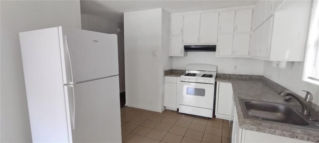 105 Anne Street Hampton, GA 30228 - Photo 2 of 15 a kitchen with a refrigerator sink and cabinets