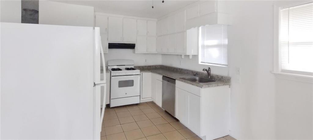 105 Anne Street Hampton, GA 30228 - Photo 4 of 15 a kitchen with white cabinets and white appliances