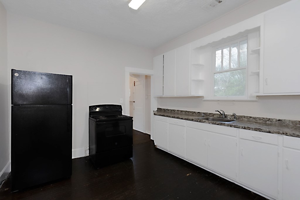 1037 30th Street Columbus, GA 31904 - Photo 9 of 16 a kitchen with a refrigerator and a stove top oven