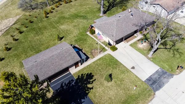 an aerial view of a house with a yard and trees