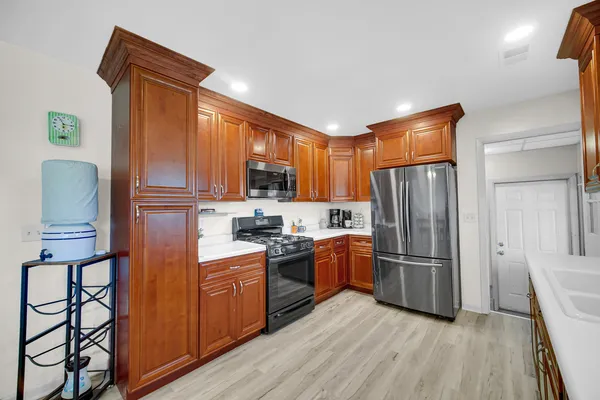 a kitchen with stainless steel appliances granite countertop a refrigerator stove top oven and sink
