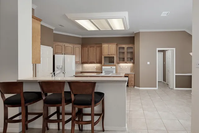 a kitchen with a dining table chairs cabinets and stainless steel appliances