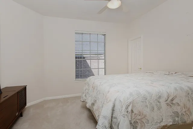 a large bed sitting in a bedroom next to a window