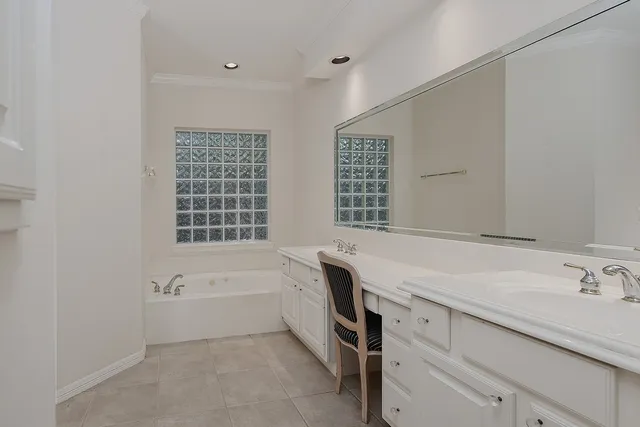 a spacious bathroom with double vanity and a bathtub