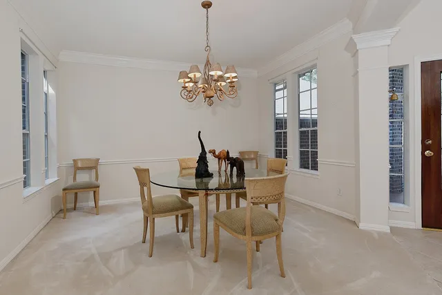 a view of a dining room with furniture a chandelier and window