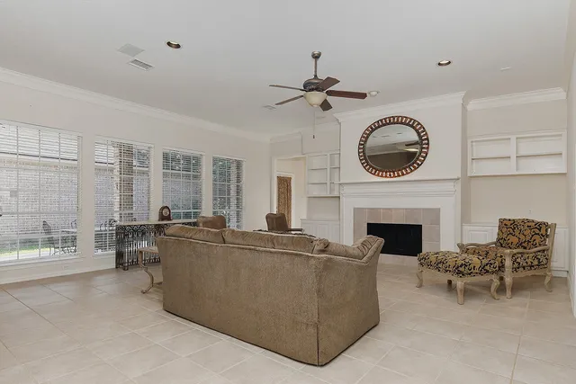 a living room with furniture a fireplace and a large window