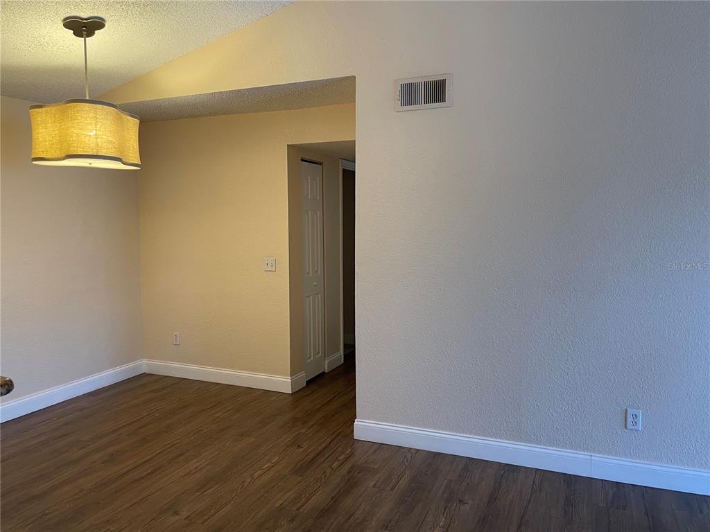5144 Conroy Road, Unit 32 Orlando, FL 32811 - Photo 9 of 16 a view of a room with wooden floor and chandelier