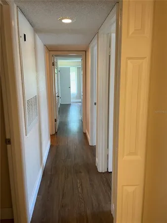 a view of a hallway with wooden floor