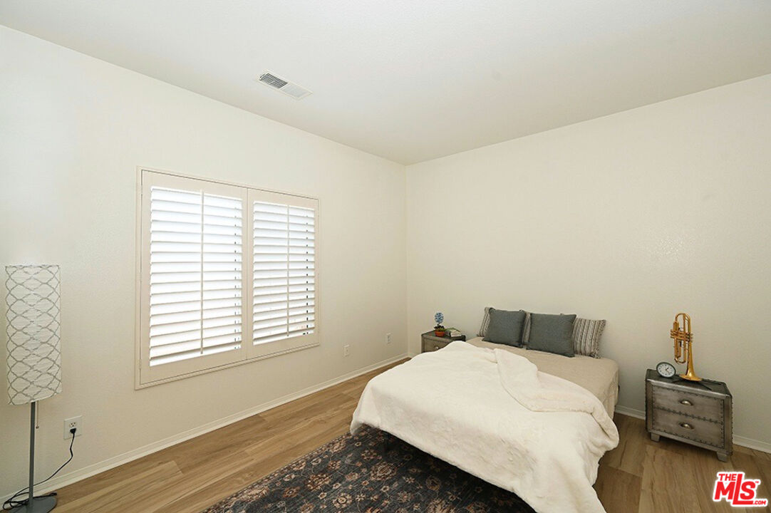 699 Alta Ridge Palm Springs, CA 92262 - Photo 15 of 31 a bedroom with a bed and wooden floor