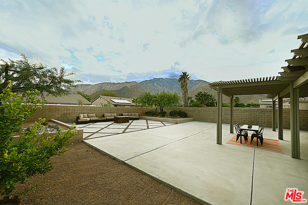 699 Alta Ridge Palm Springs, CA 92262 - Photo 21 of 31 a view of a swimming pool with a table and chairs
