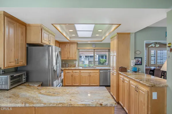 a kitchen with stainless steel appliances kitchen island granite countertop a refrigerator and a sink