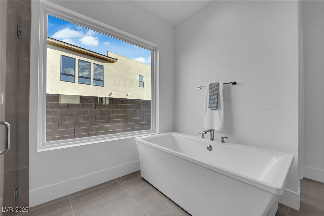 4792 Outlook Peak Street Las Vegas, NV 89135 - Photo 27 of 56 Full bathroom featuring a freestanding tub, light tile patterned flooring, and a shower stall