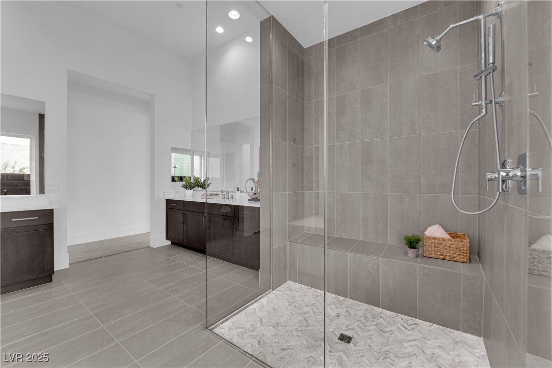 4792 Outlook Peak Street Las Vegas, NV 89135 - Photo 28 of 56 Bathroom with vanity, a tile shower, light tile patterned floors, and recessed lighting