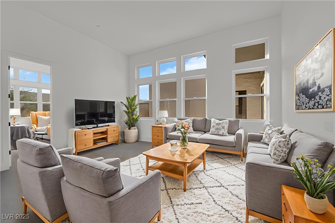 4792 Outlook Peak Street Las Vegas, NV 89135 - Photo 30 of 56 Living room featuring a towering ceiling and healthy amount of natural light