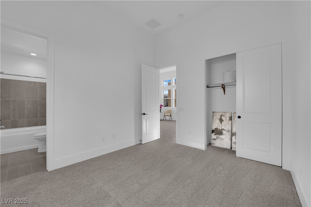 4792 Outlook Peak Street Las Vegas, NV 89135 - Photo 42 of 56 Unfurnished bedroom featuring light colored carpet, a closet, and ensuite bathroom