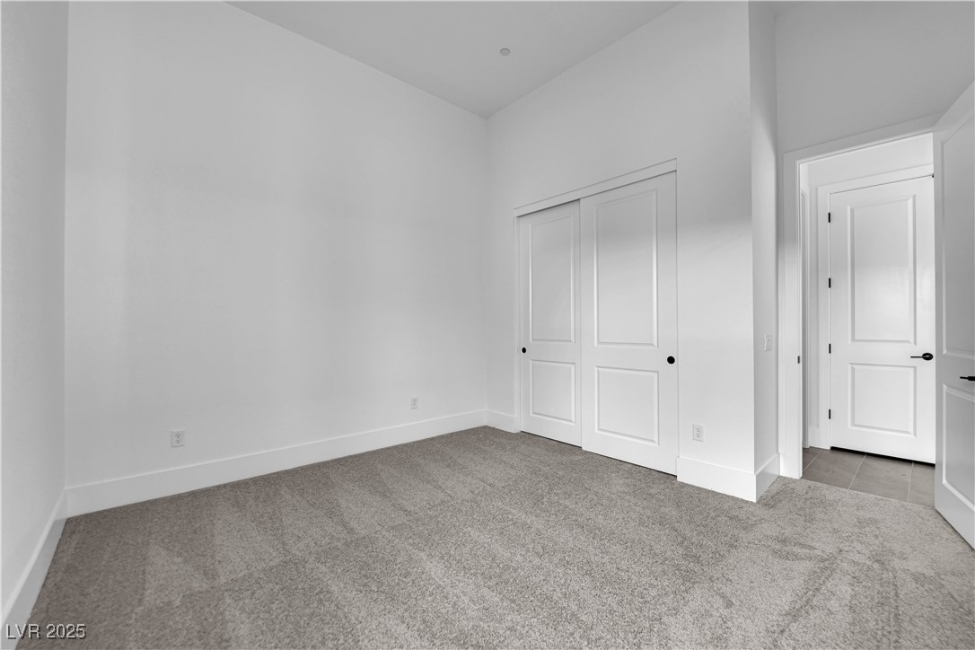 4792 Outlook Peak Street Las Vegas, NV 89135 - Photo 47 of 56 Unfurnished bedroom with light carpet and a closet