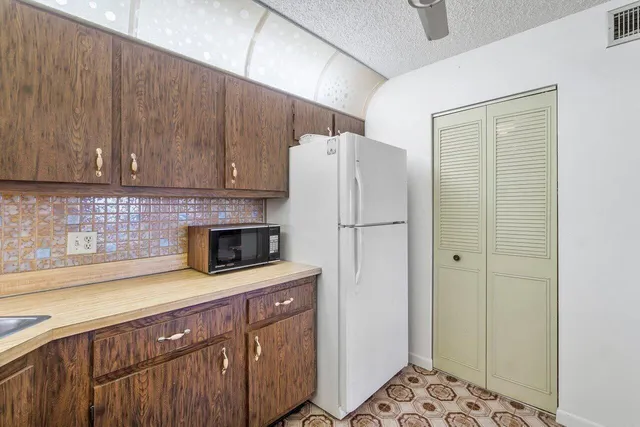 a kitchen with a sink a refrigerator and cabinets