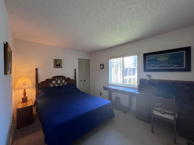 a bedroom with a bed dresser and a window