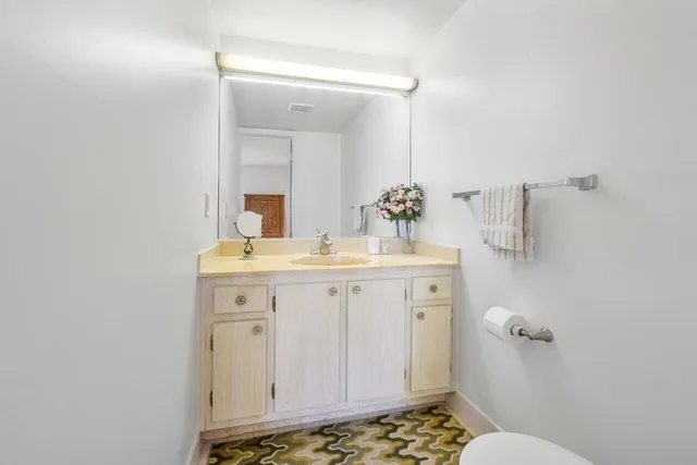 a bathroom with a sink a toilet and mirror