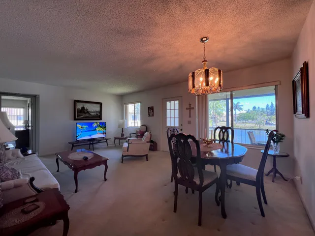 a living room with furniture a large window and a chandelier