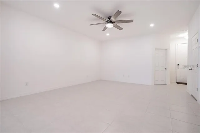 an empty room with a ceiling fan and a window