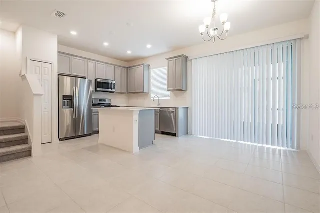 a view of kitchen with refrigerator cabinets and furniture