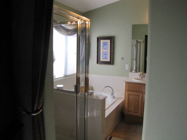 8992 Del Rio Circle Gilroy, CA 95020 - Photo 18 of 19 a bathroom with a bathtub a mirror a sink and next to a window