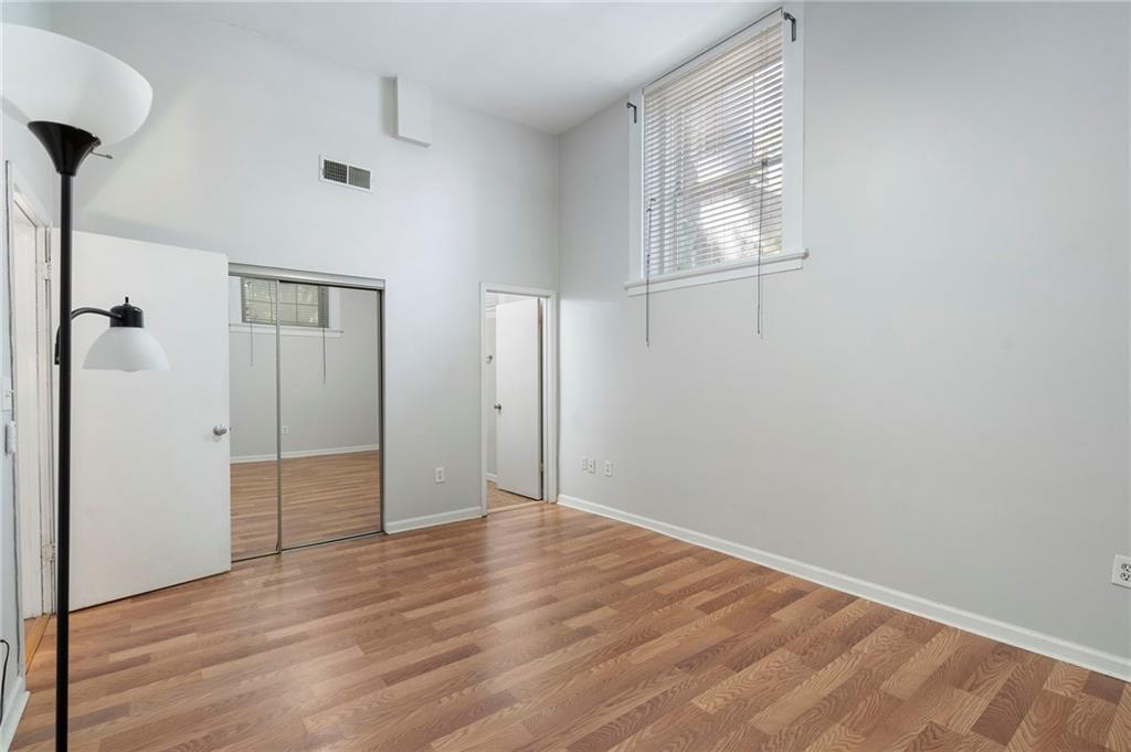1031 State Street Northwest, Unit 106 Atlanta, GA 30318 - Photo 14 of 23 an empty room with wooden floor and windows
