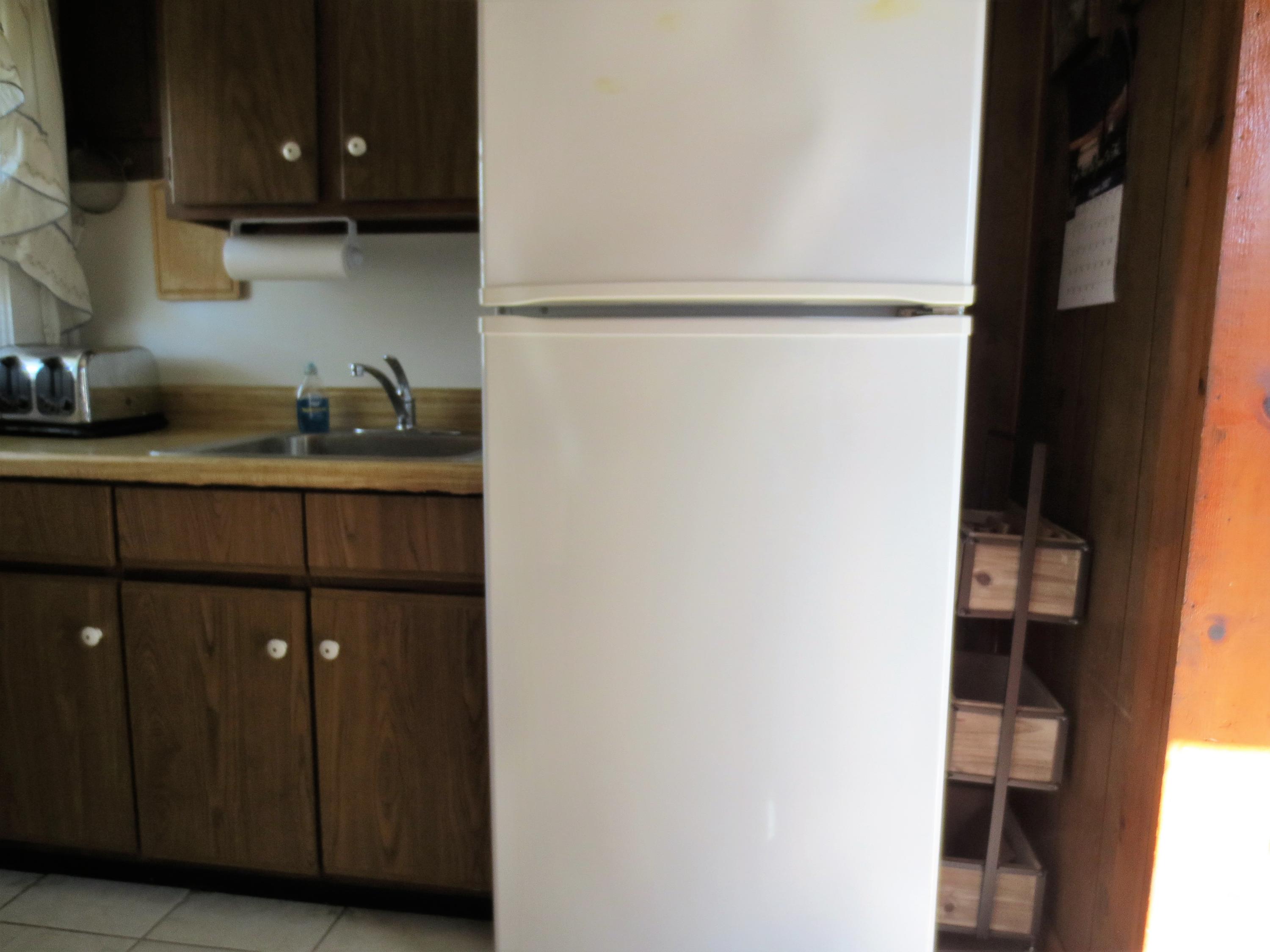 291 Lower County Road, Unit E Dennis Port, MA 02639 - Photo 13 of 31 a kitchen with a refrigerator and cabinets