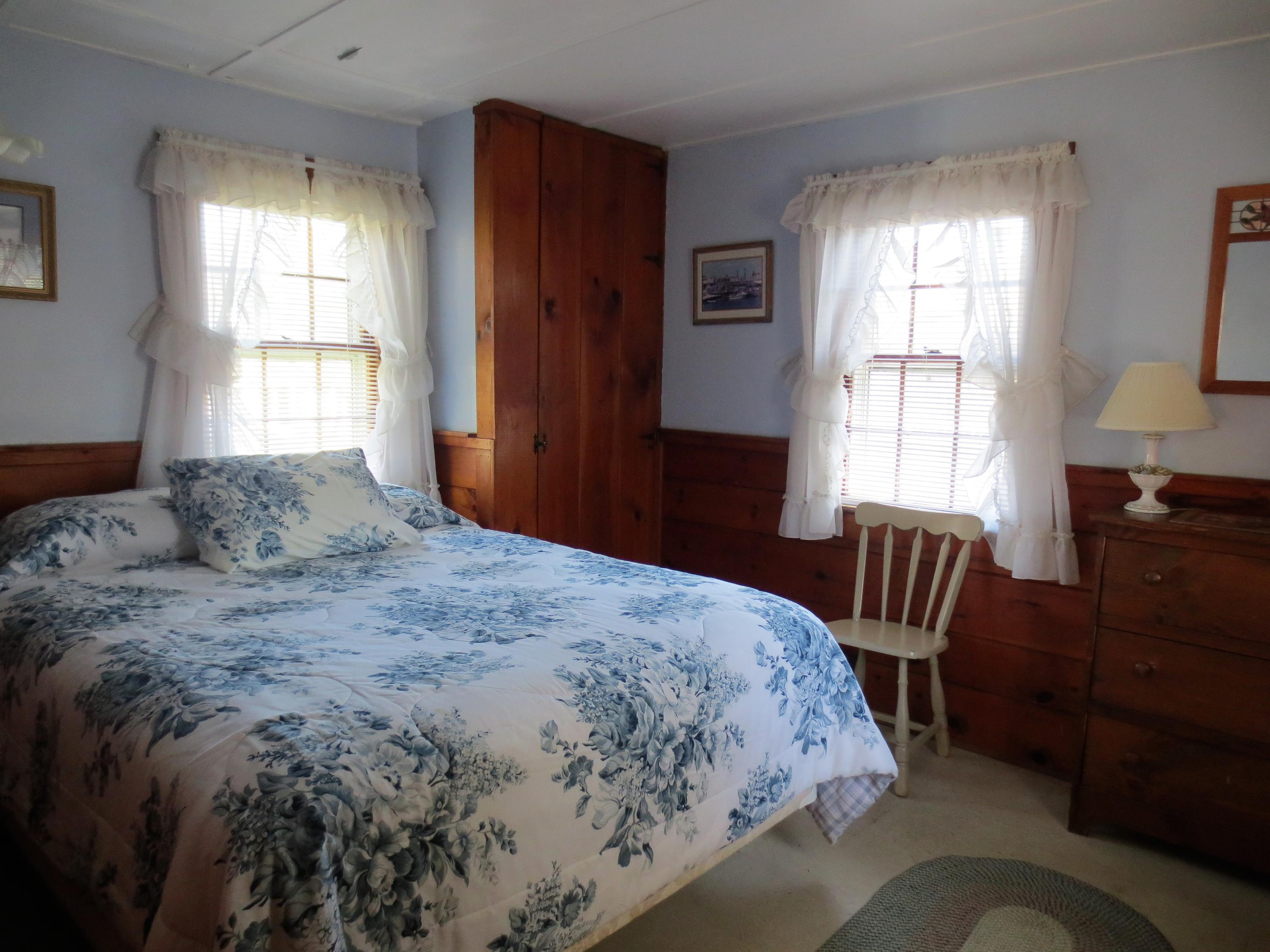 291 Lower County Road, Unit E Dennis Port, MA 02639 - Photo 17 of 31 a bedroom with a bed and wooden floor