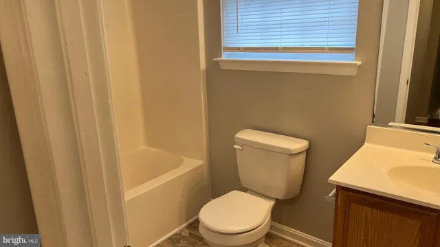 a white toilet sitting next to a bath tub