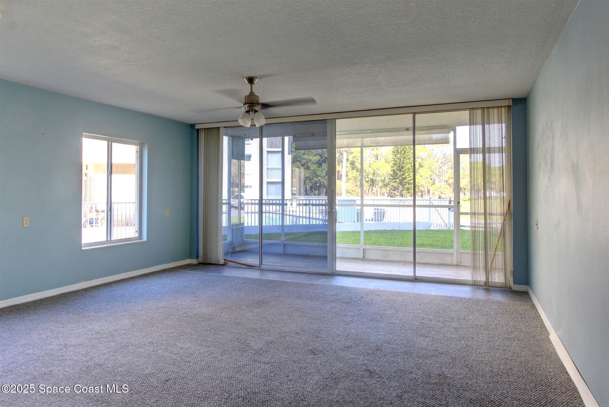 1420 Huntington Lane, Unit 2101 Rockledge, FL 32955 - Photo 13 of 38 an empty room with windows and ceiling fan