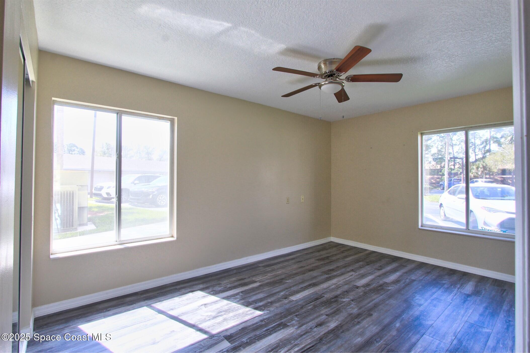 1420 Huntington Lane, Unit 2101 Rockledge, FL 32955 - Photo 28 of 38 a view of empty room with wooden floor and fan