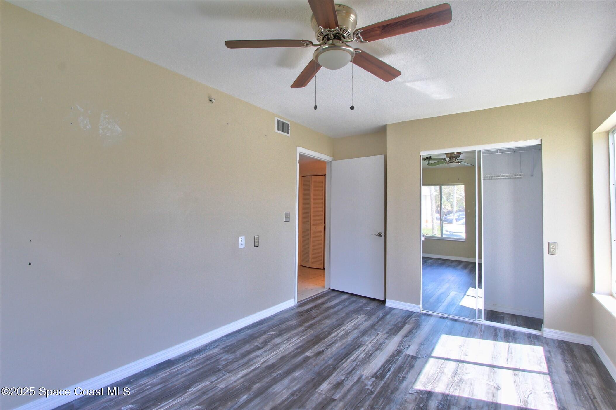 1420 Huntington Lane, Unit 2101 Rockledge, FL 32955 - Photo 29 of 38 wooden floor in an empty room with a window