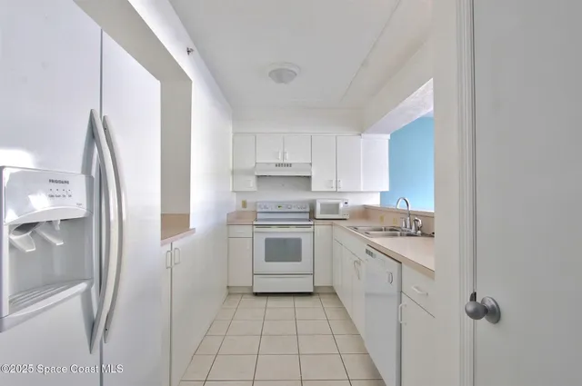 a kitchen with a sink and a refrigerator