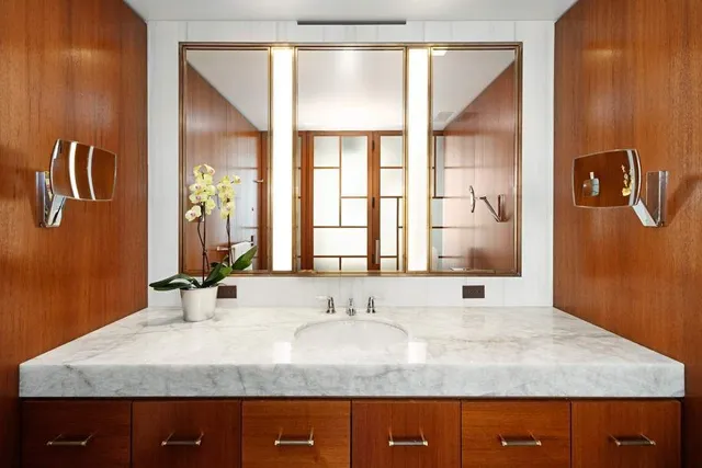 a bathroom with a granite countertop sink and a mirror