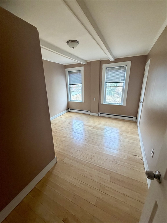18 Avon Street, Unit B Reading, MA 01867 - Photo 11 of 14 an empty room with wooden floor and windows