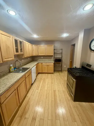 a large kitchen with stainless steel appliances granite countertop a stove and a sink