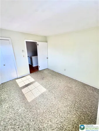 a view of empty room with window and wooden floor
