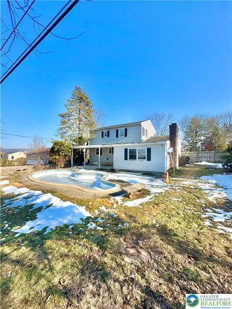 a house view with swimming pool next to a yard