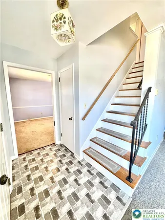 a view of a hallway with wooden floor and a bathroom