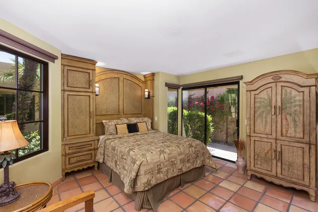 a bedroom with a bed a dresser next to a window