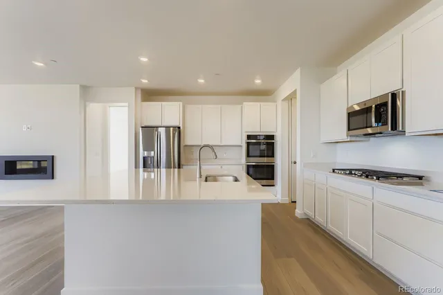 a kitchen with stainless steel appliances a refrigerator sink and microwave