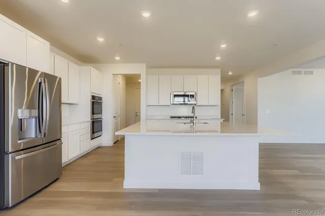 a kitchen with stainless steel appliances granite countertop a sink and refrigerator