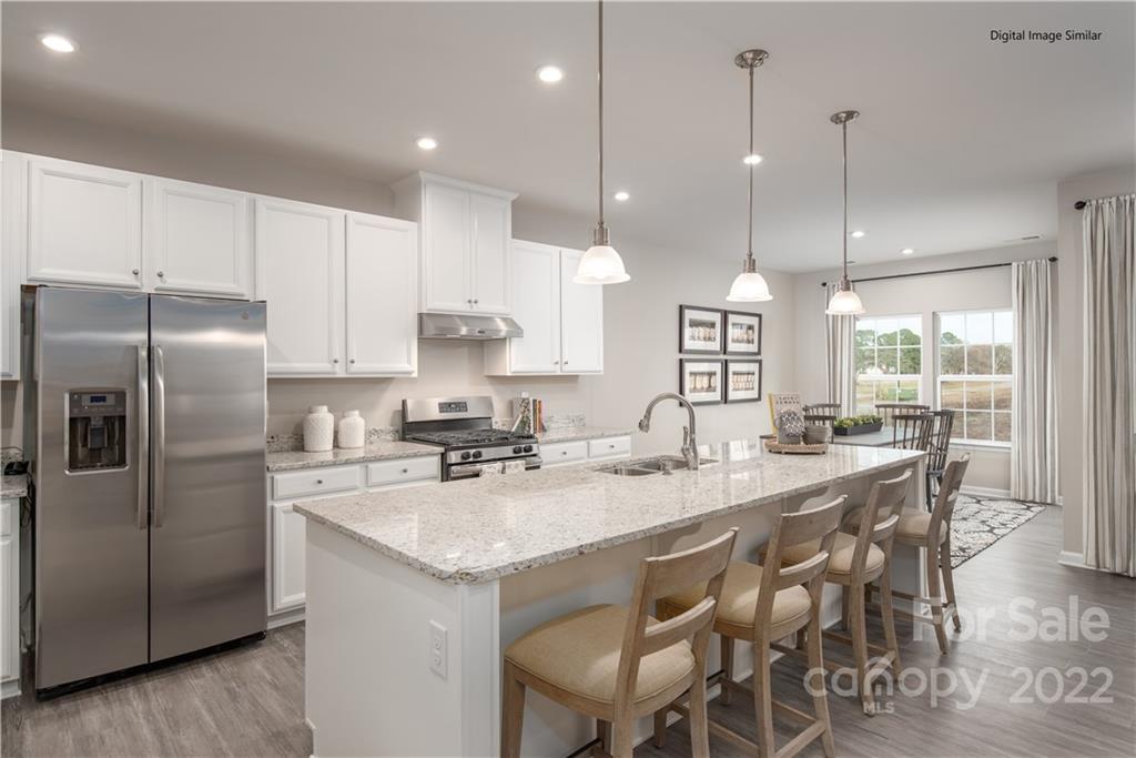 3032 Ballester Road, Unit 250 Indian Land, SC 29707 - Photo 7 of 18 a kitchen with granite countertop a center island a sink stainless steel appliances and cabinets