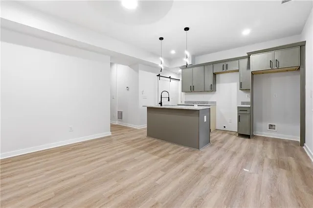 a view of a kitchen with a sink refrigerator and wooden floor