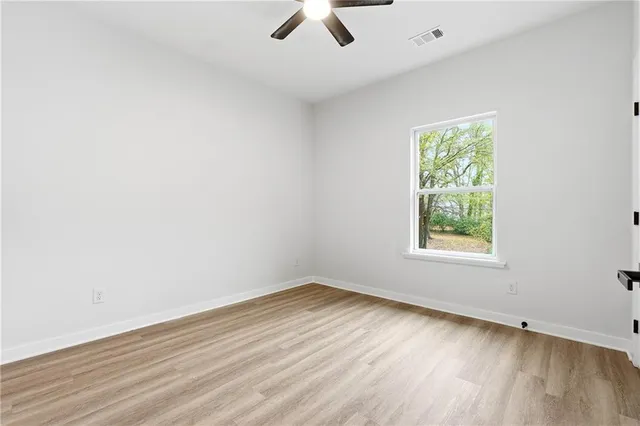 an empty room with a window and a ceiling fan