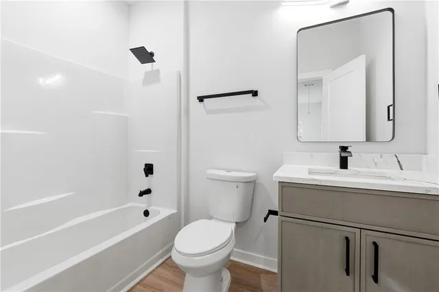 a bathroom with a sink toilet vanity and shower