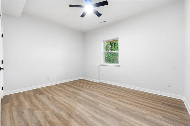 an empty room with a window and a ceiling fan